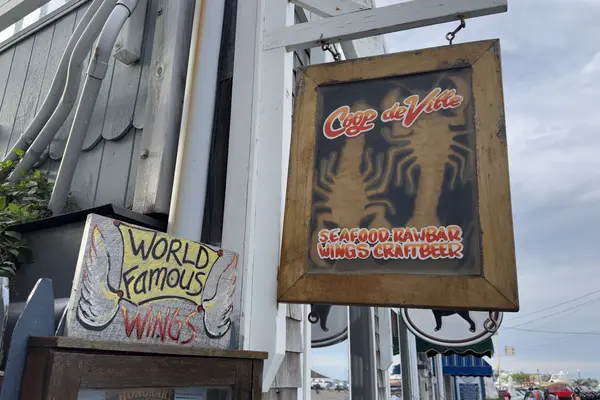 Coop de Ville on Circuit Avenue Extension: the hanging sign and the World Famous Wings board