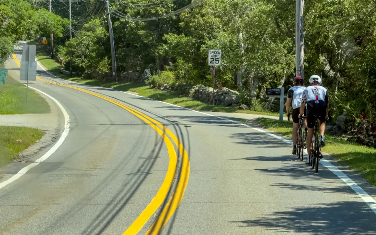 Two road cyclists on a narrow up-island road on Martha's Vineyard