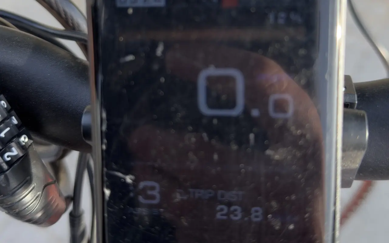 Close-up of an e-bike handlebar display showing 0.0 speed, assist level 3, trip distance 23.8 and 12 percent battery