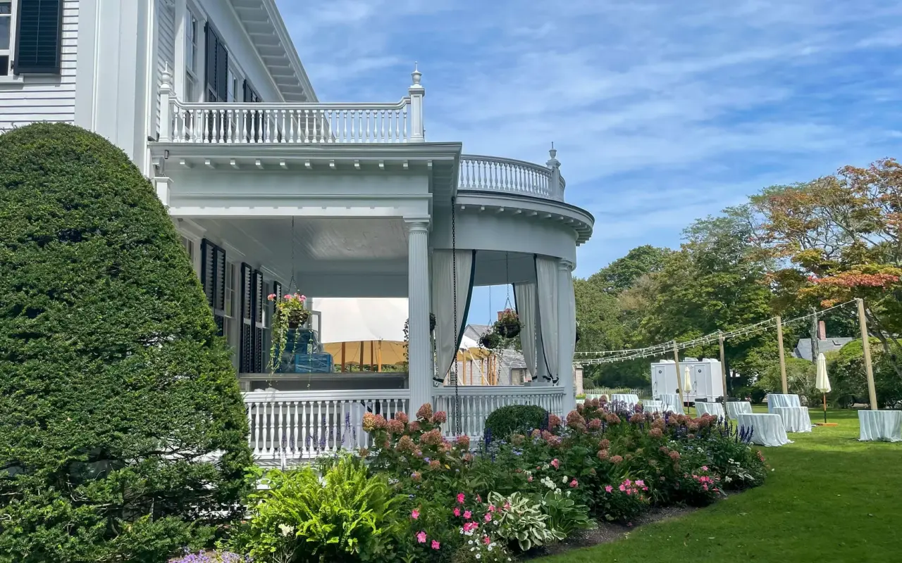 The columned porch and rose garden of the Dr. Daniel Fisher House in Edgartown