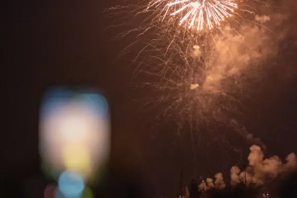 Fireworks bursting over Edgartown Harbor as onlookers watch