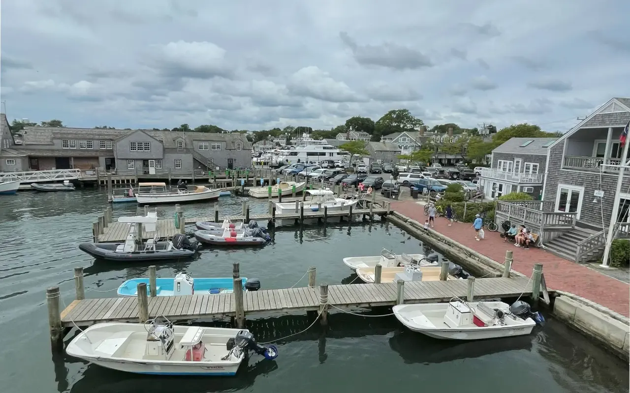 Small boats tied up at wooden docks in Edgartown Harbor under an overcast sky