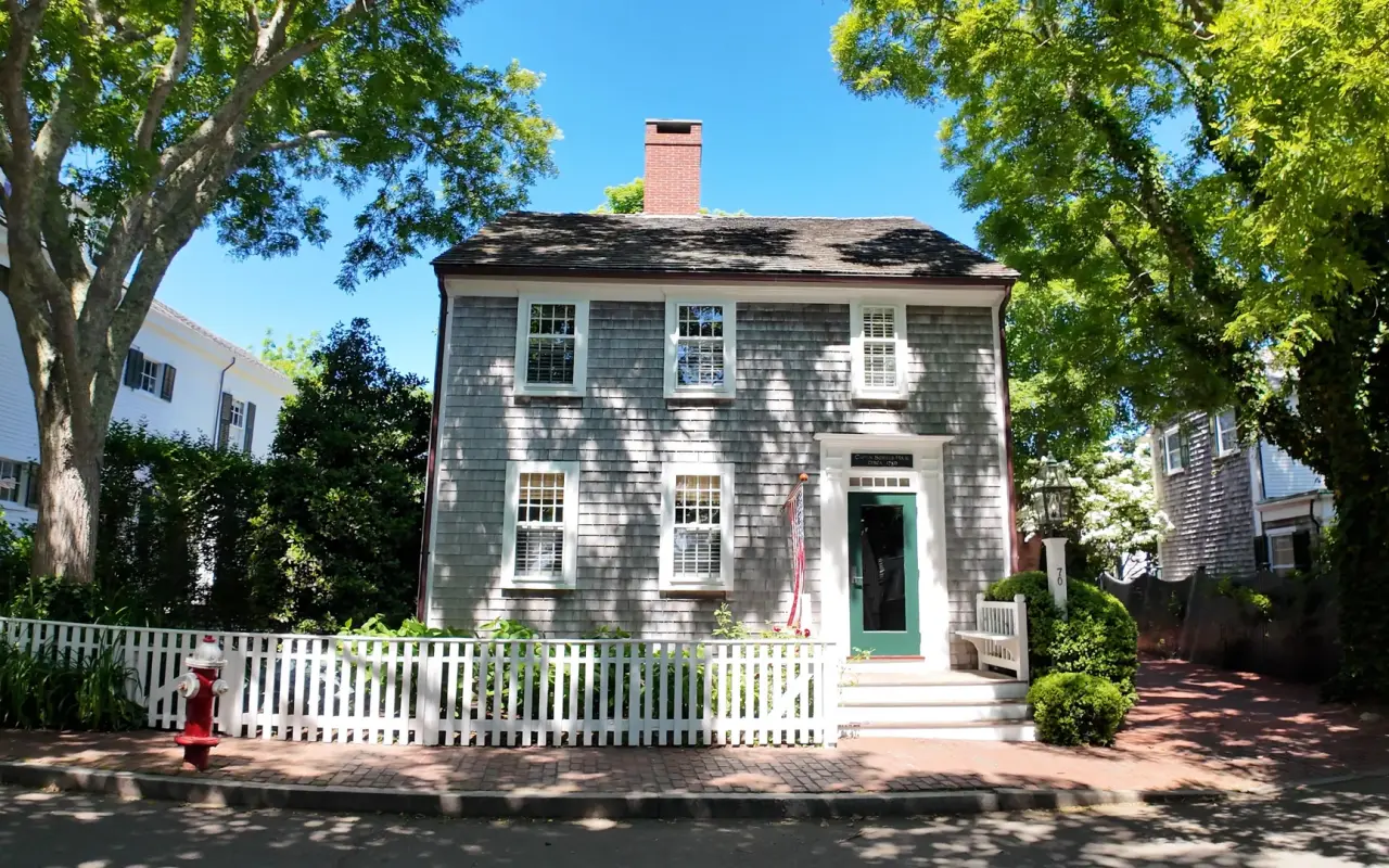 Grey-shingled historic house with a white picket fence in Edgartown village