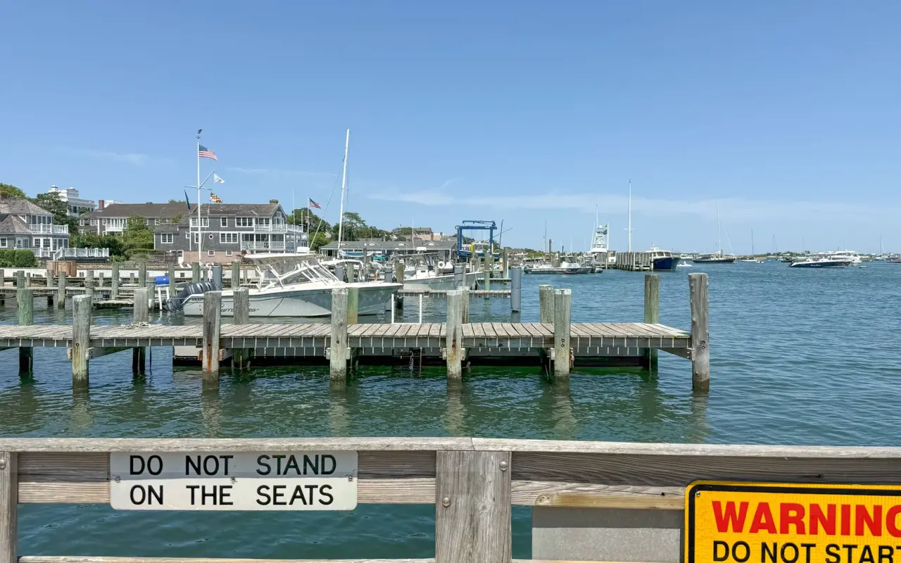 Edgartown Harbor on a July day with wooden docks, moored powerboats and the town waterfront in the background