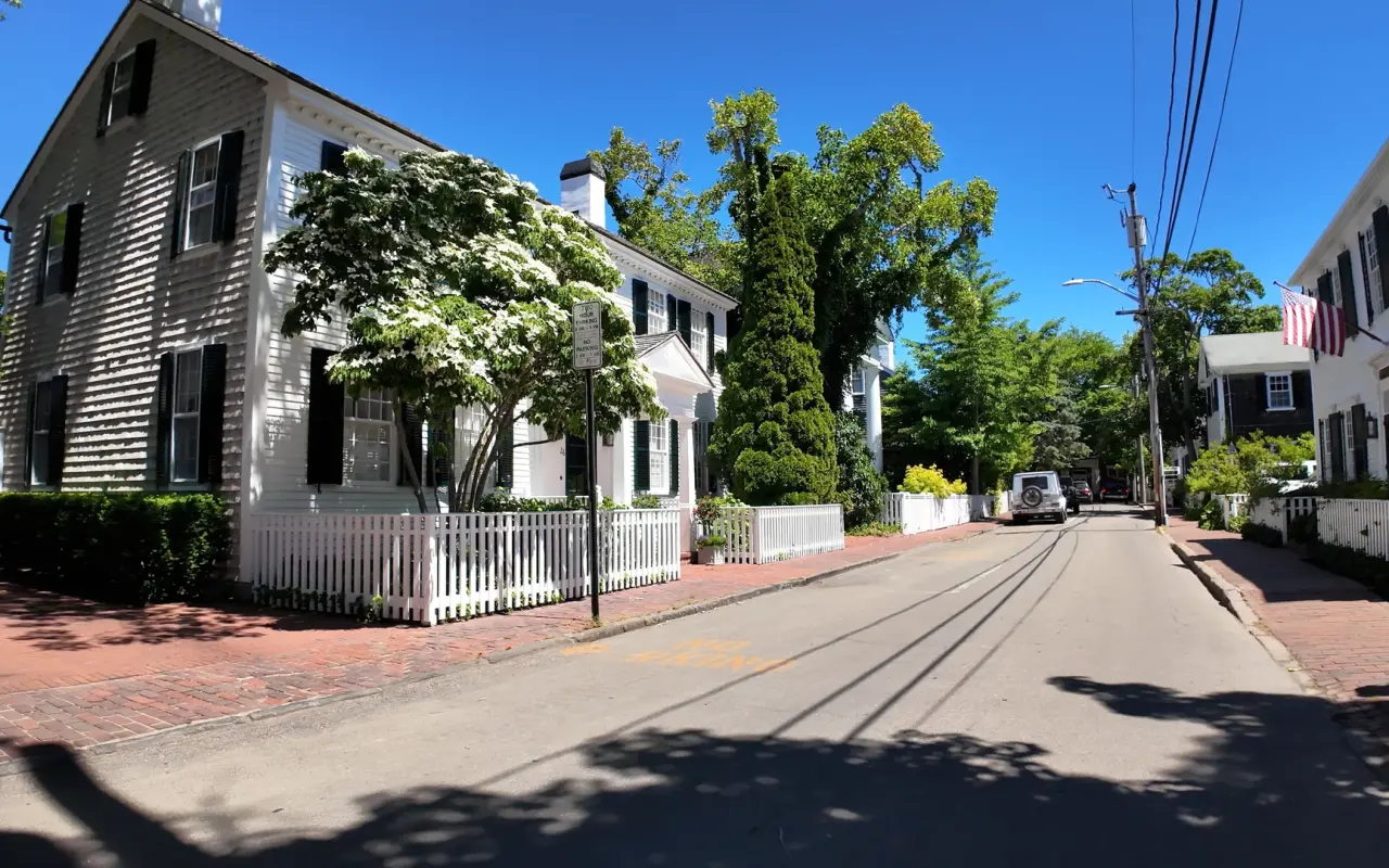 Shaded Edgartown street with white houses and a picket fence in June