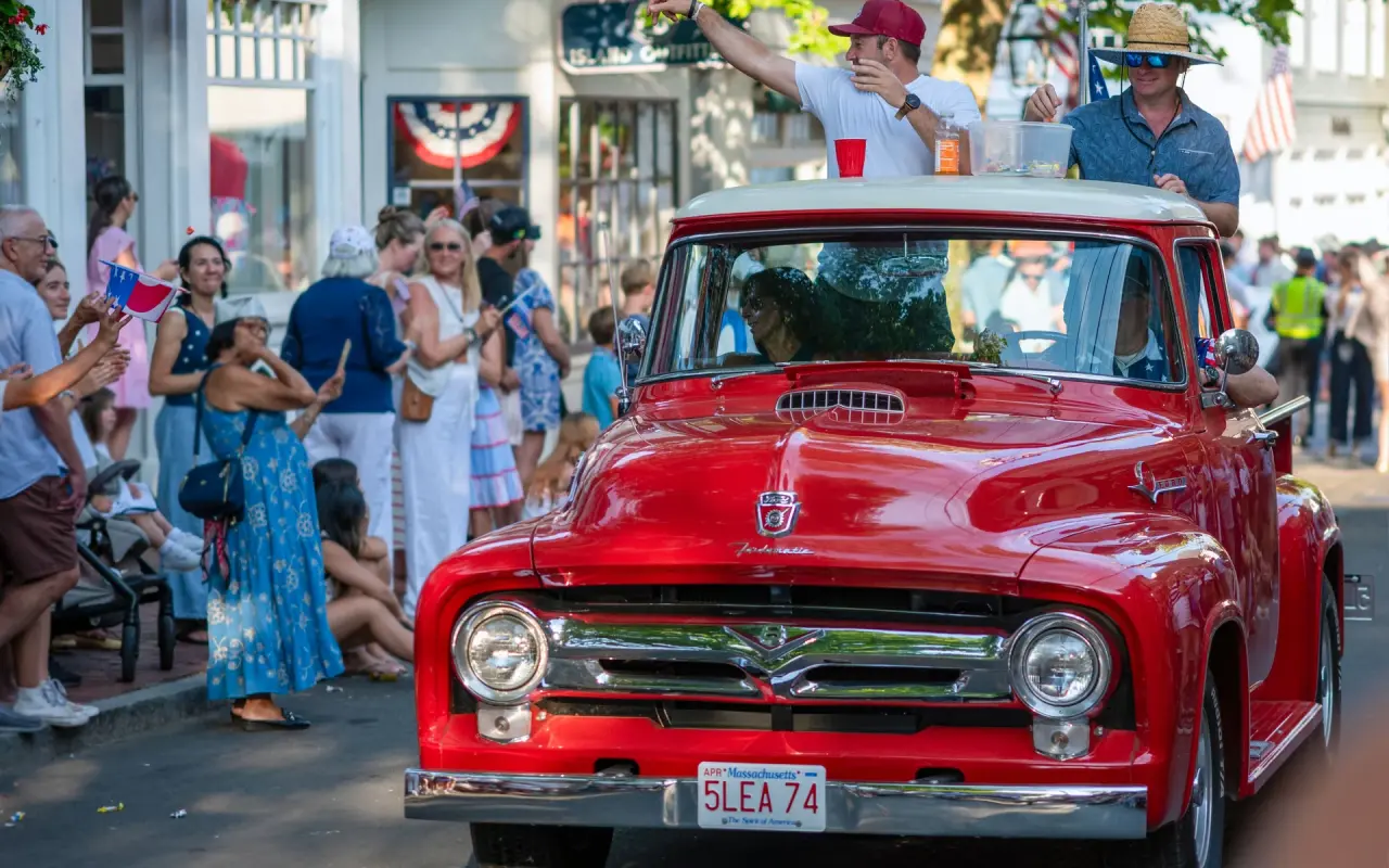 A classic red pickup rolling down Main Street in Edgartown's Fourth of July parade