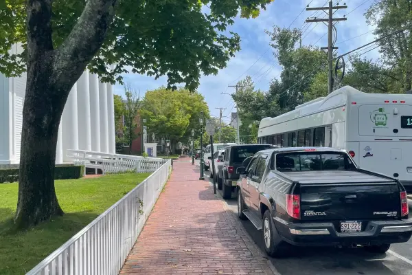 Parked cars and a VTA bus on a shady Edgartown street