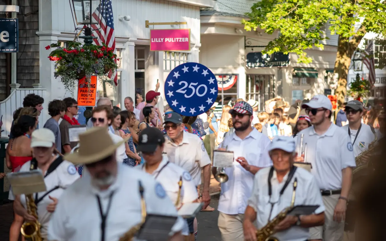 A marching band with saxophones and white shirts on Main Street in Edgartown during the Fourth of July parade