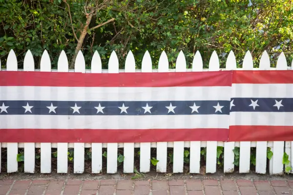 Patriotic stars-and-stripes bunting on a white picket fence, Edgartown Fourth of July