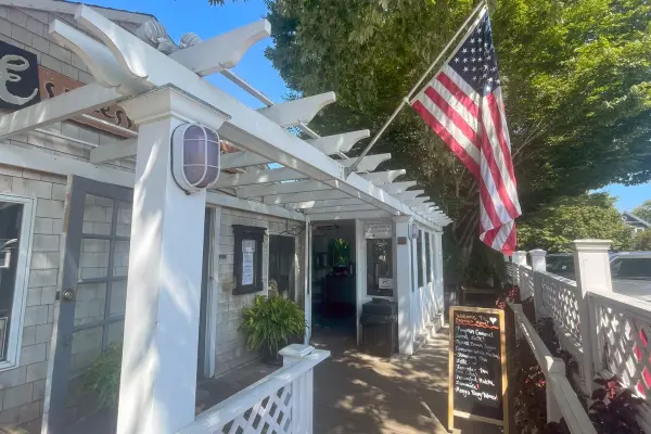Patio entrance with flag and menu board at Espresso Love
