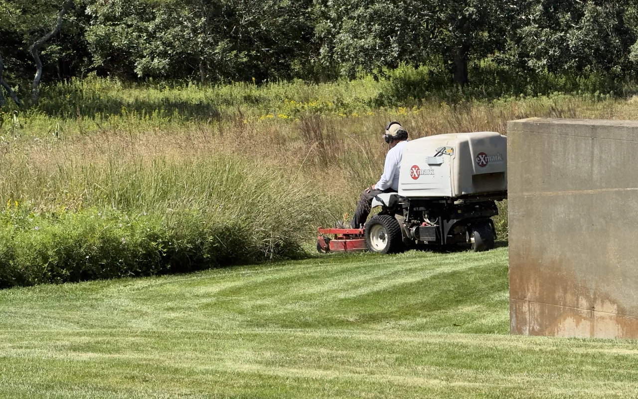 A landscaper on an Exmark mower trimming the edge of a meadow on Martha's Vineyard