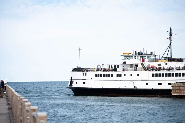 The Nantucket coming in to the Oak Bluffs wharf, a fisherman on the jetty