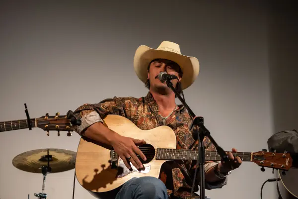 Fuller, straw cowboy hat and paisley shirt, on a Taylor