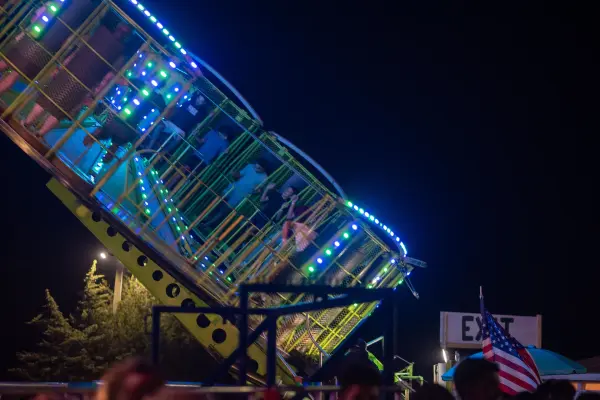 Riders tilt toward the night sky as the platform swings up