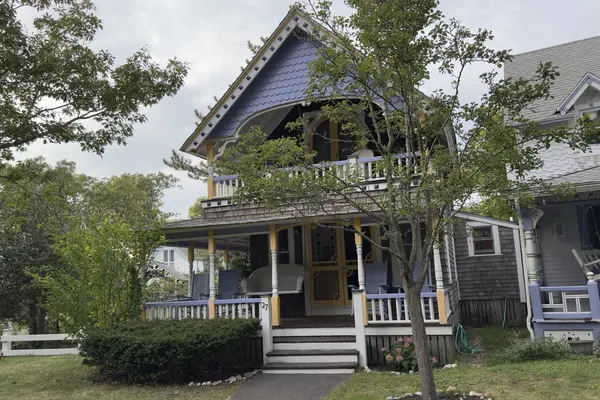 Number 27: a purple fish-scale gable, yellow posts and a balcony over the porch