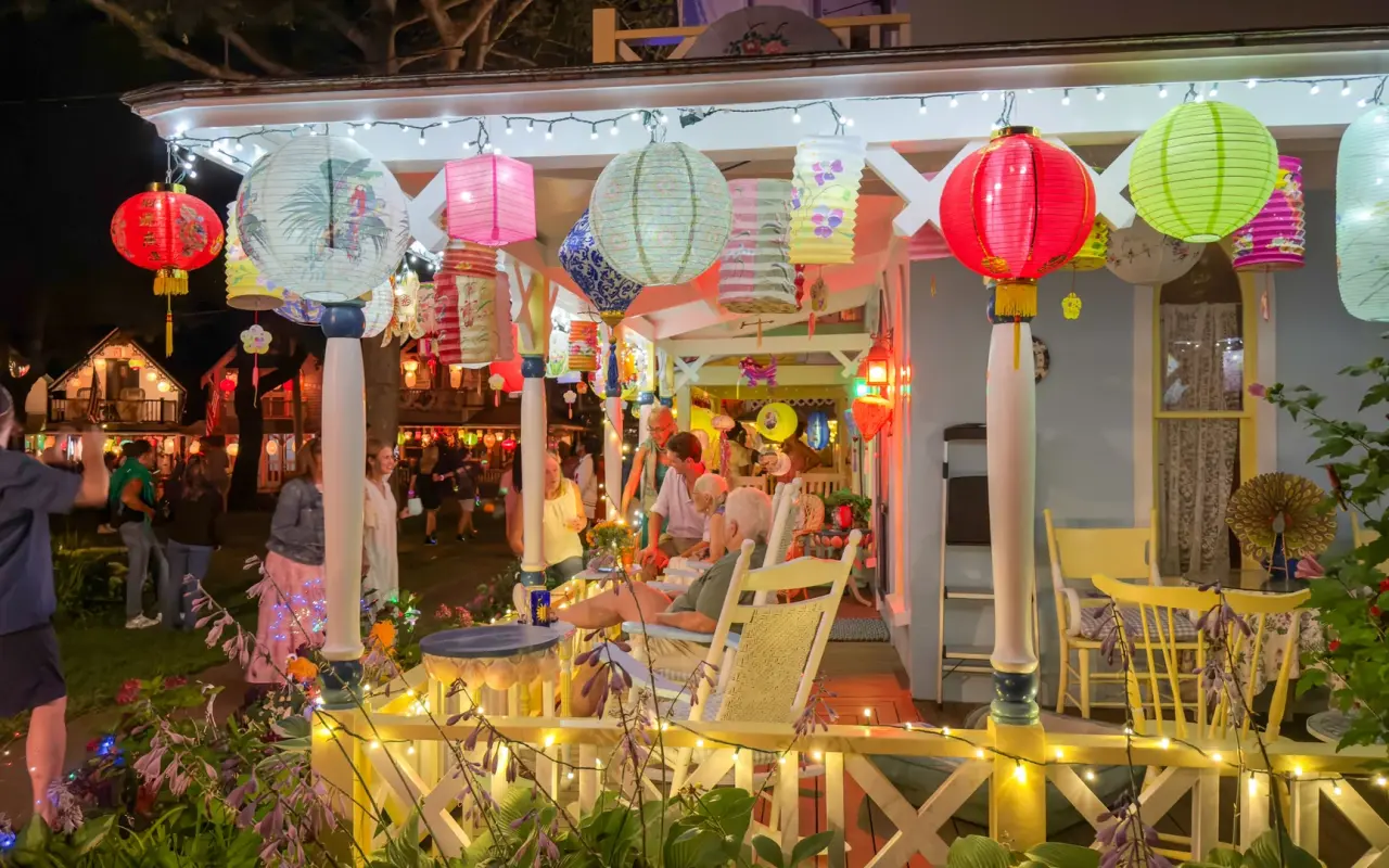 Gingerbread cottage porch strung with lit paper lanterns during Illumination Night