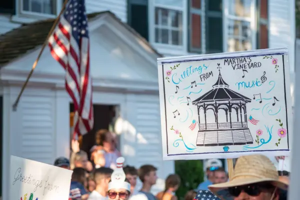 A hand-painted "Greetings from Martha's Vineyard - Music" bandstand sign in the Edgartown Fourth of July parade