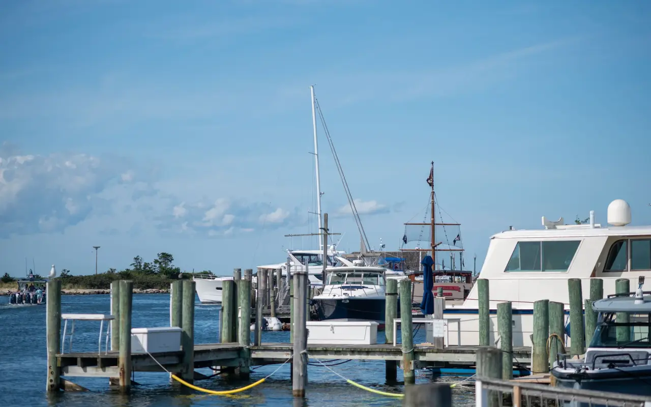 Motorboats tied up at wooden docks in Oak Bluffs harbor on a clear summer day