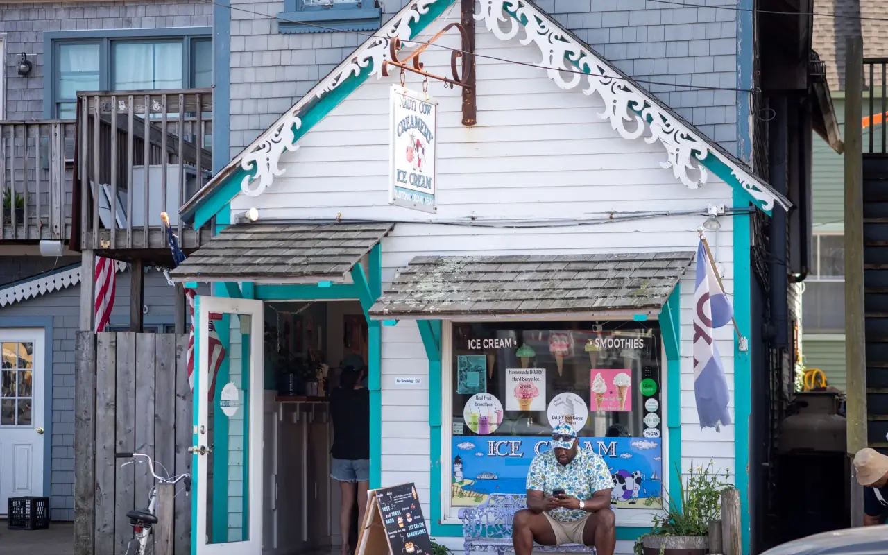 A small white and turquoise ice cream stand with gingerbread trim in Oak Bluffs on a summer day