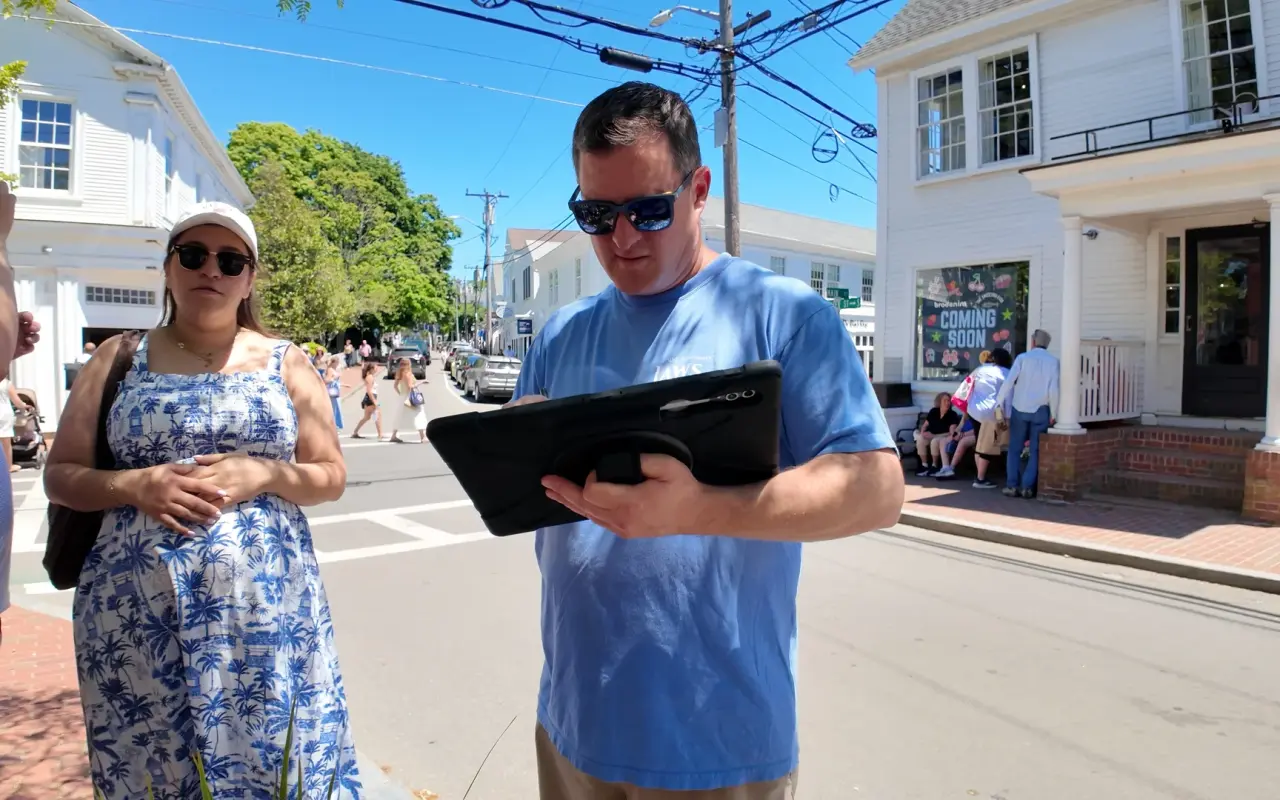 Tour guide holding a tablet on Main Street in Edgartown during a Jaws walking tour