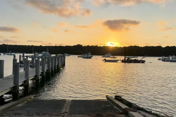 Sunset over the dock and boats at Lake Tashmoo