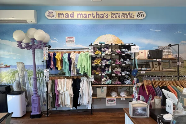 Inside Mad Martha's, est. 1971: the merchandise wall under a painted dune.