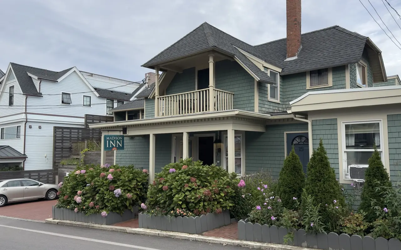 The Madison Inn on Kennebec Avenue in Oak Bluffs with green shingles, a balcony and hydrangeas
