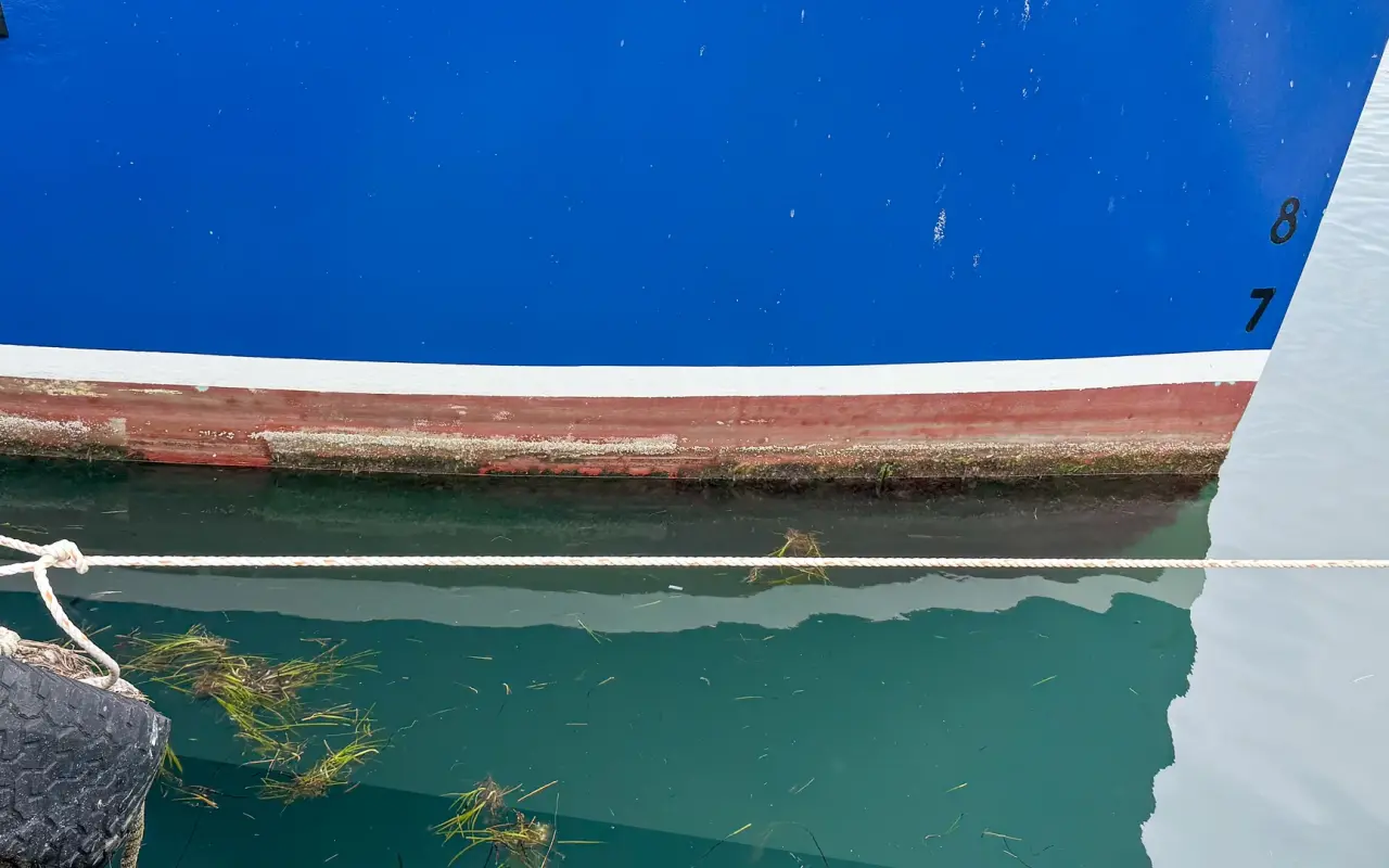Hull of a fishing boat at the waterline in Menemsha harbor
