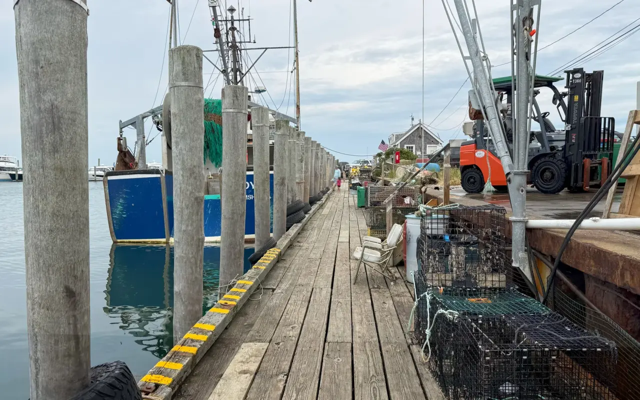 Lobster pots and fishing boats along the plank wharf at Dutcher Dock, Menemsha