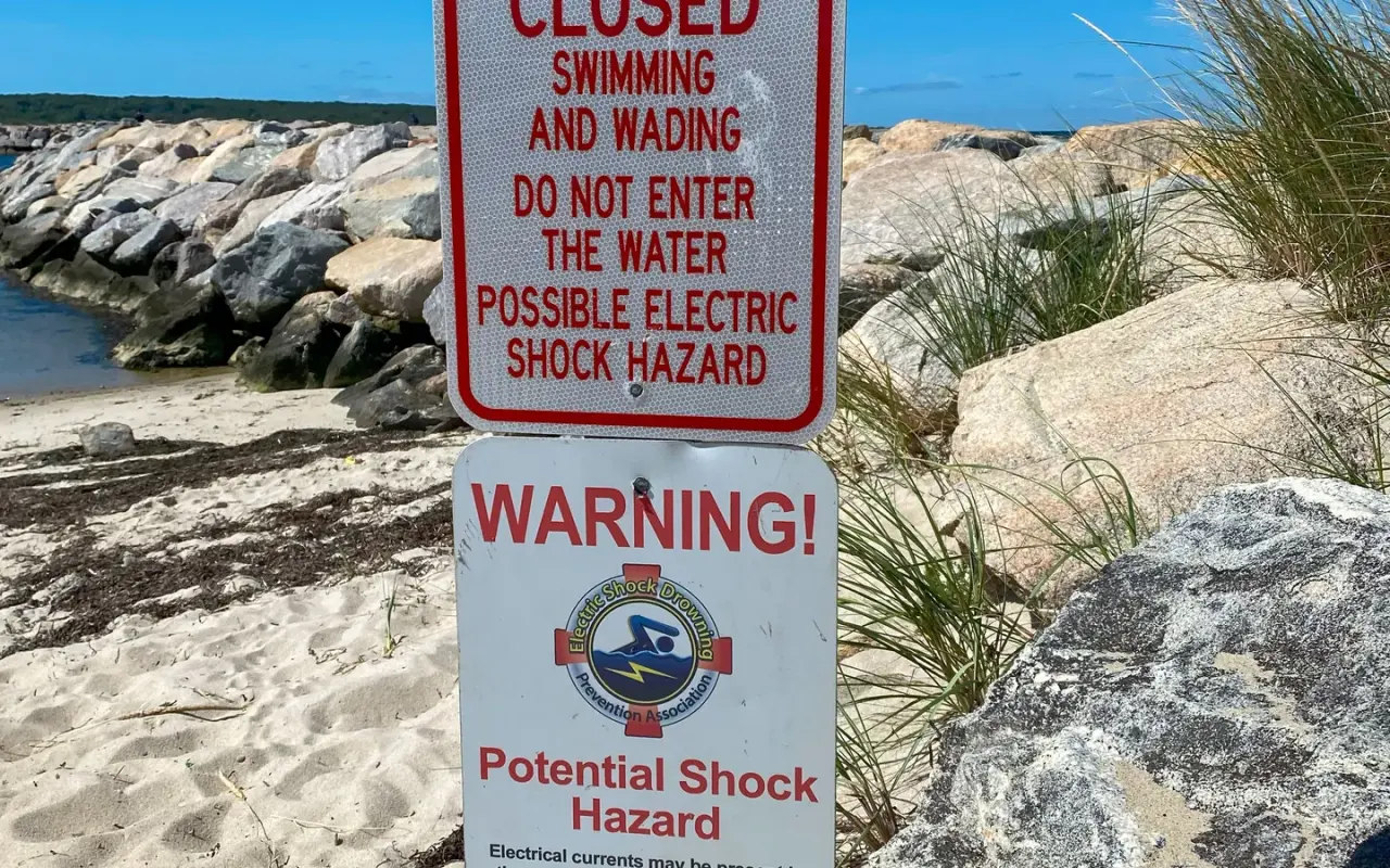 Red posted sign at Menemsha closing swimming and wading for a possible electric shock hazard