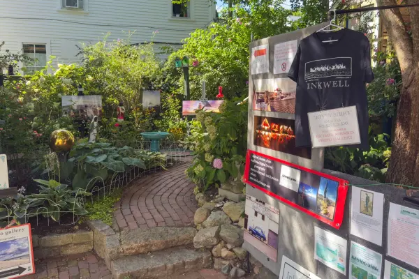 Print boards and an Inkwell shirt along the garden path at the Michael Johnson Photo Gallery.