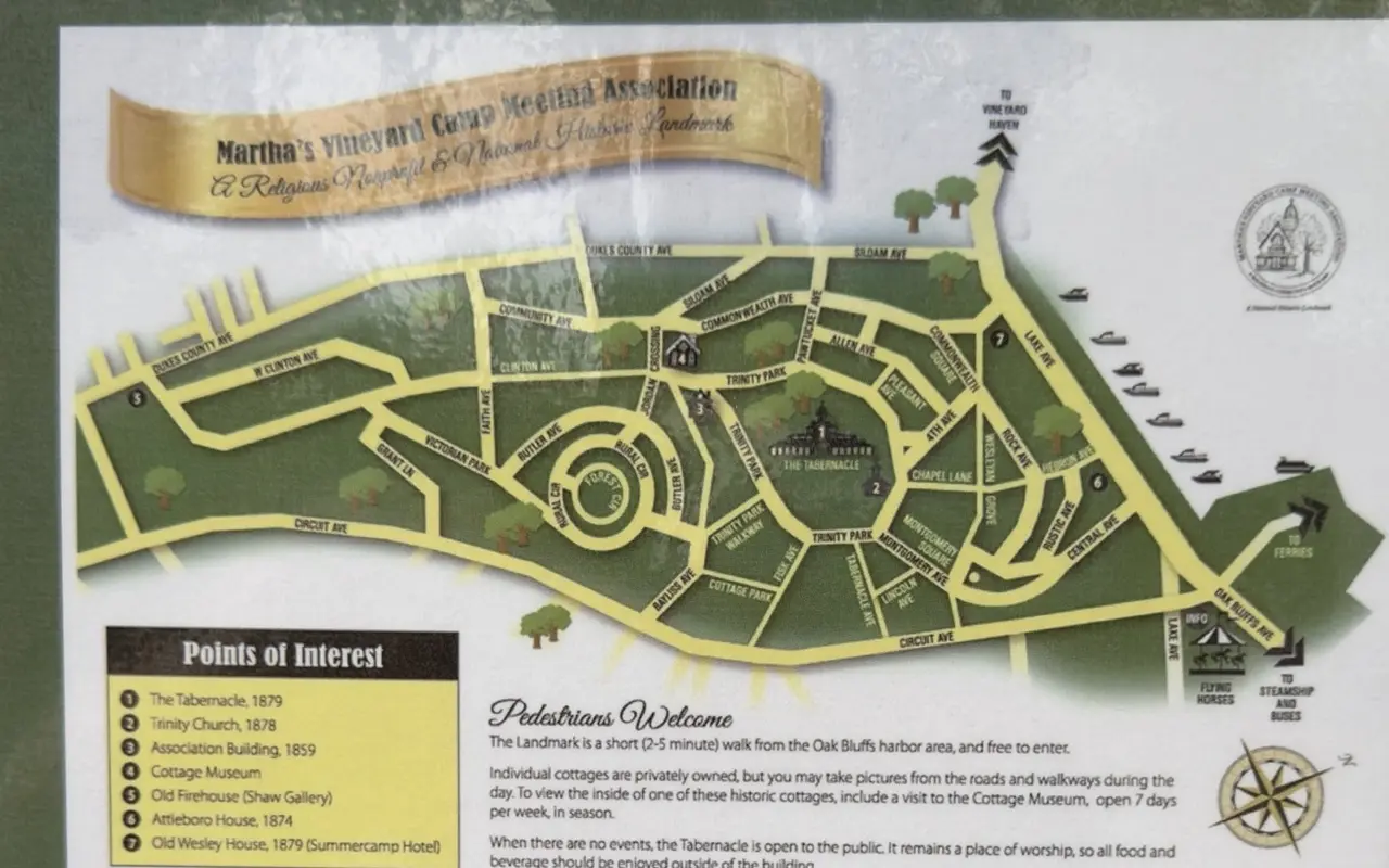 The Camp Meeting Association's map of the Campground posted on a green notice board: yellow lanes around the Tabernacle, seven numbered points of interest, a Pedestrians Welcome note and a compass rose