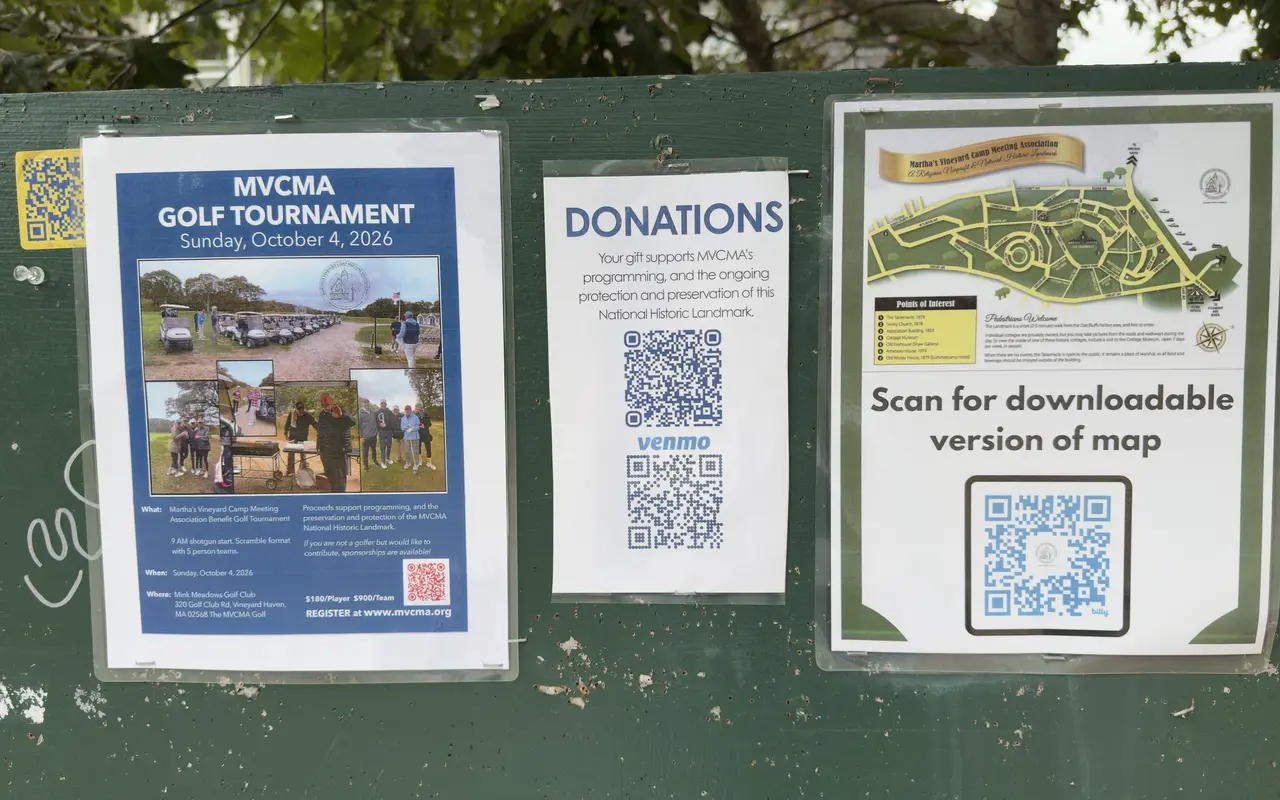 A green notice board in the Oak Bluffs Campground with three laminated sheets: a flyer for the MVCMA golf tournament on Sunday, October 4, 2026, a Donations sheet with QR codes, and the Campground map with a scan-to-download code