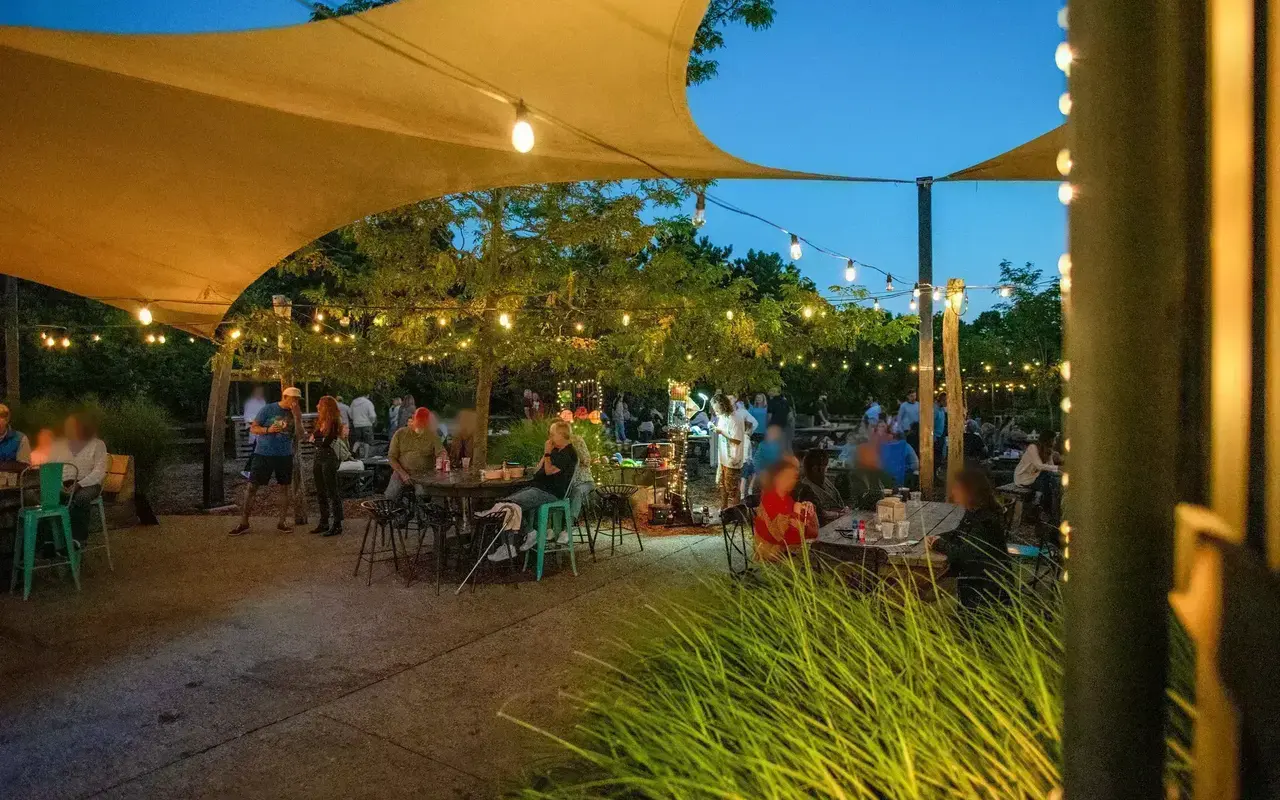 Outdoor tables at Nomans in Oak Bluffs under sail shades and string lights at dusk