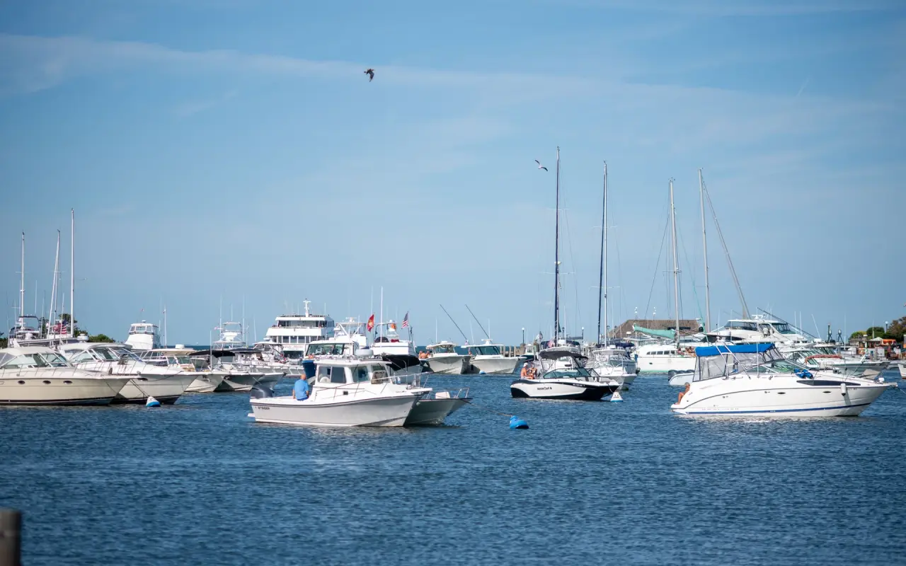 A crowded Oak Bluffs harbor in August with dozens of moored and docked boats under a hazy sky