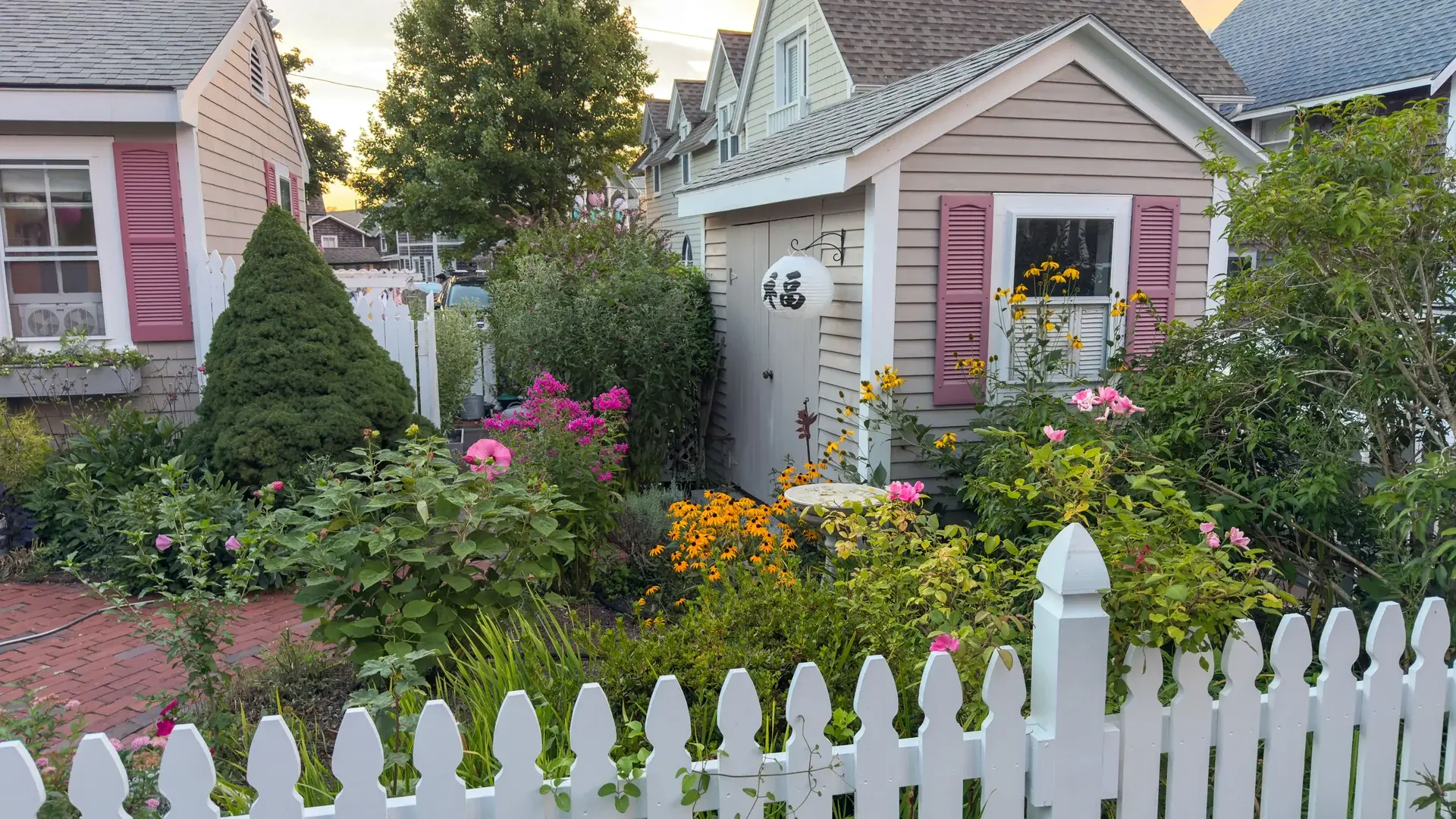 Dusk in the campground: cottage gardens and a lantern waiting for dark