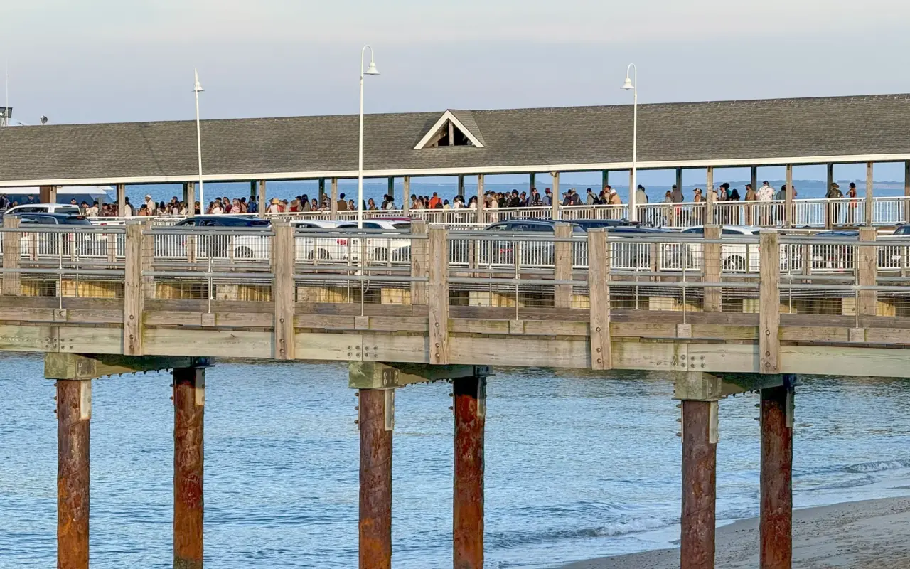 Crowds of passengers waiting on the covered Oak Bluffs ferry pier in summer