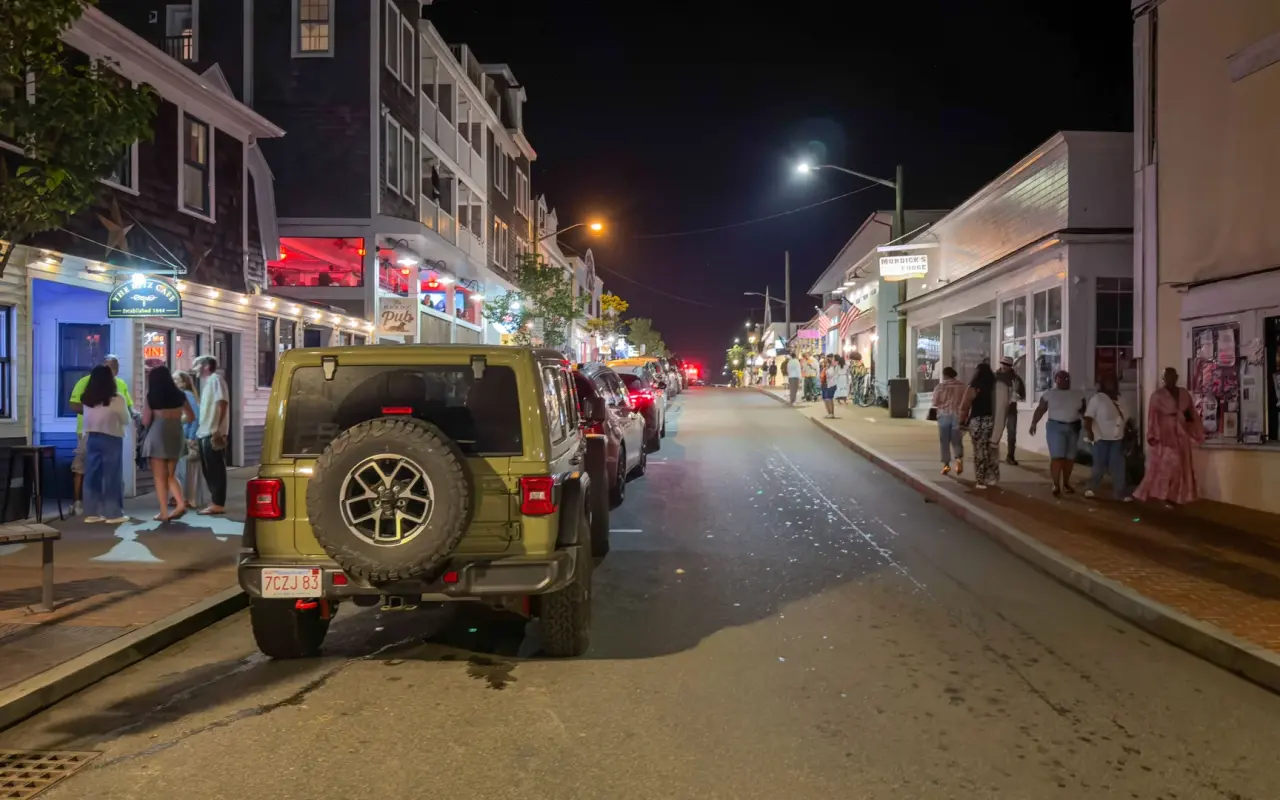 Circuit Avenue in Oak Bluffs at night with bars lit and people on the sidewalks