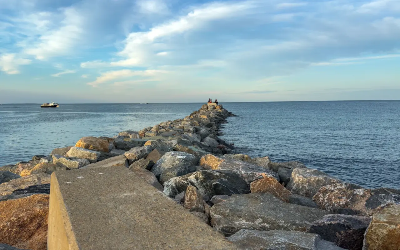 People sitting at the end of the stone jetty in Oak Bluffs