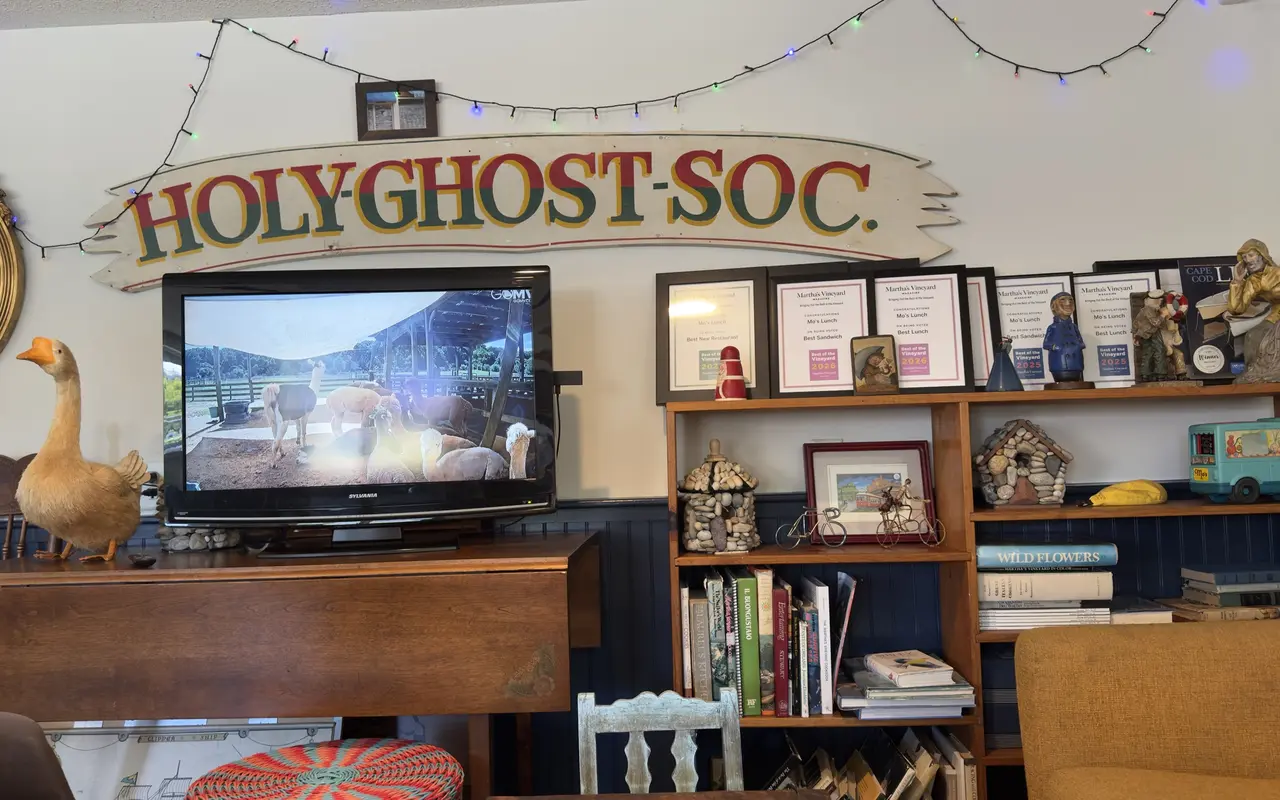 Inside the Portuguese-American Club in Oak Bluffs: the Holy Ghost Soc. sign, a television, a stuffed goose and a shelf of framed Best of the Vineyard awards for Mo's Lunch