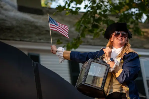 A costumed reenactor with lantern and flag on the "Paul Revere" float in the Edgartown Fourth of July parade