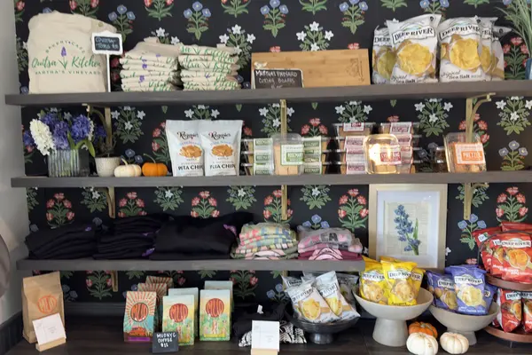 The retail shelves at Quitsa Kitchen: totes, cutting boards, chips, hoodies and Mud coffee