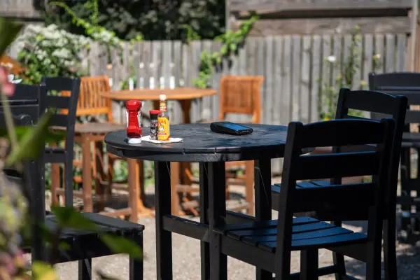 A patio high-top between services: ketchup, hot sauce and a phone