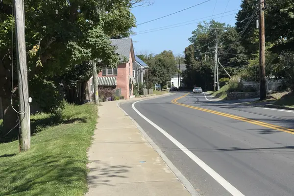 The road into Vineyard Haven under the maples, a pink house with a striped awning