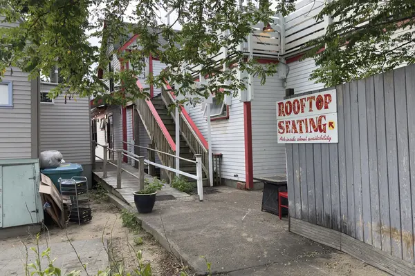 A Rooftop Seating sign in an Oak Bluffs alley, the stair to the deck behind it