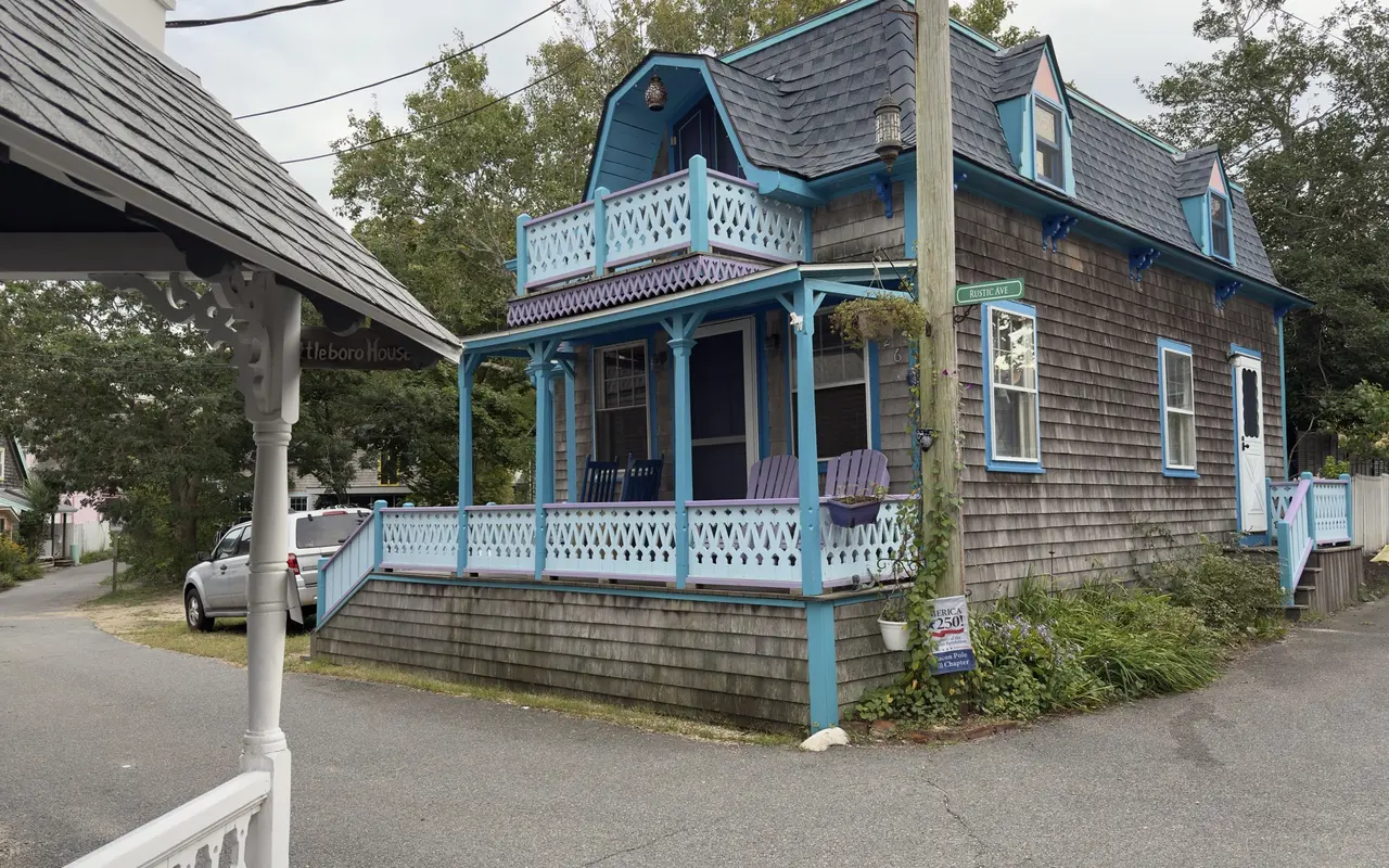 A cottage with turquoise and lavender trim on Rustic Avenue in the Campground
