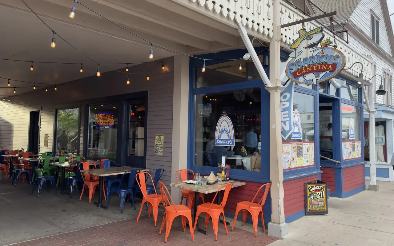 The patio at Sharky's Cantina on Circuit Avenue in Oak Bluffs with orange and blue metal chairs, string lights and the shark sign