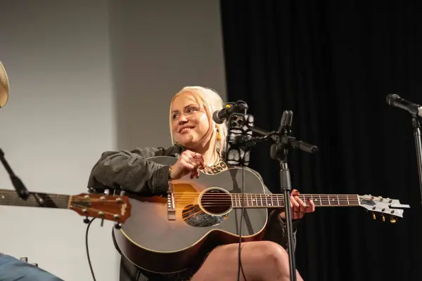 Stacey Kelleher between songs, an arm resting on her guitar