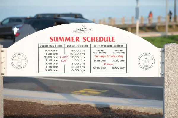 The Island Queen summer schedule board at the dock