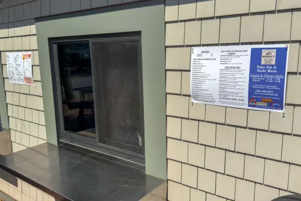 Takeout window at The Net Result with the sushi and seafood menus posted